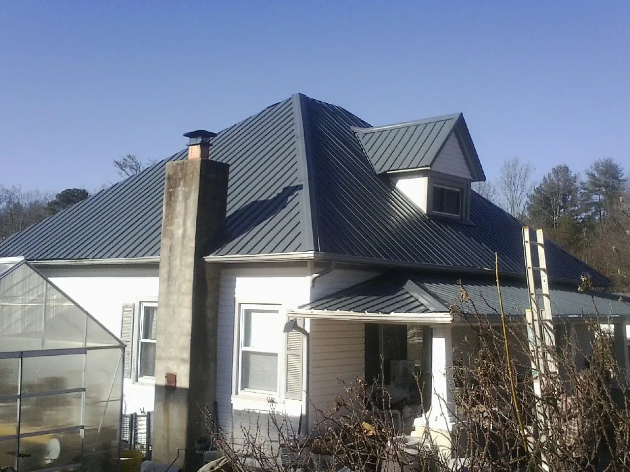 Dark blue standing seam metal roof on a white farmhouse with dormer — Slate & Tile Roof Repair by Roofing Brothers in Warner Springs