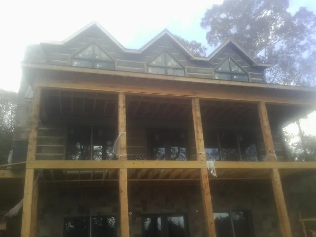 Dormers and porch framing on a large log home under construction — Roof Coating work by our crew in Warner Springs