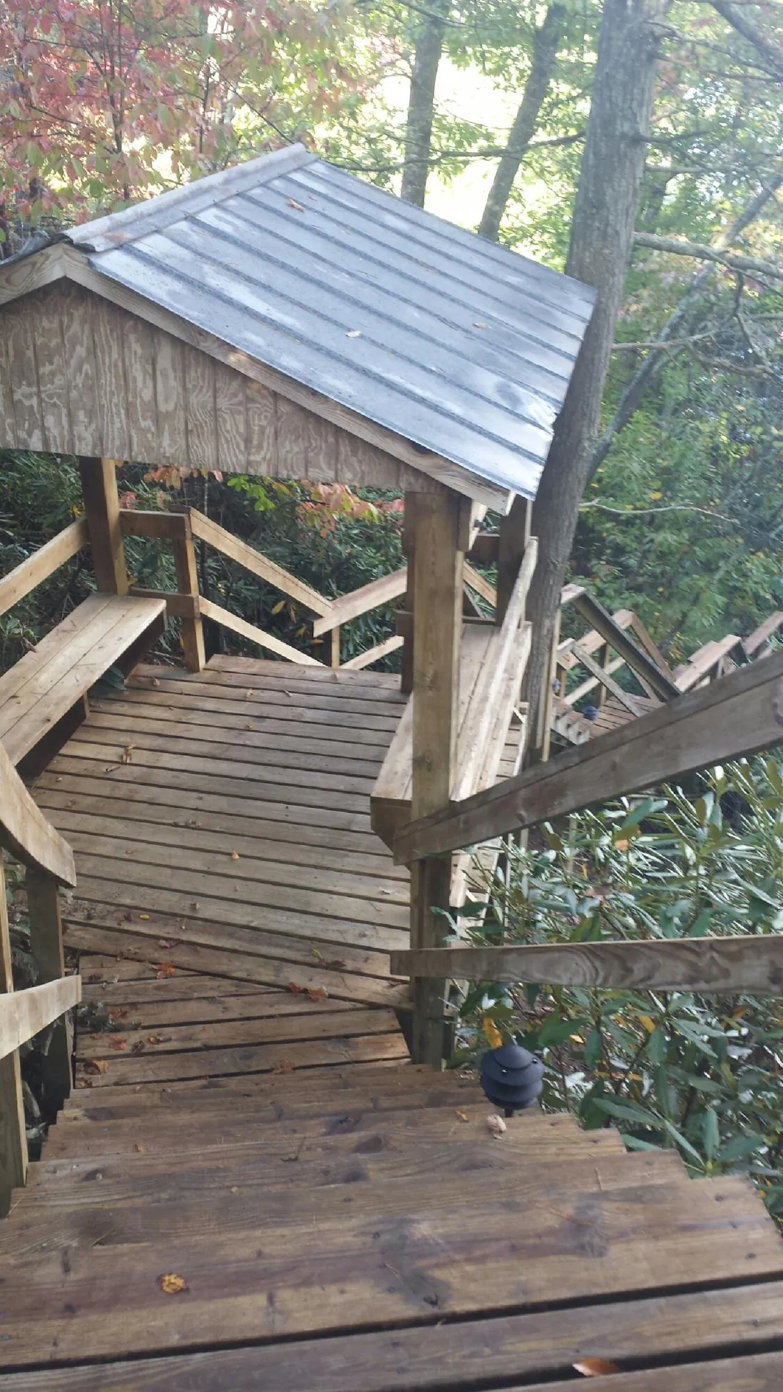 Metal roofed shelter over wooden steps on a wooded walkway — Skylight Repair & Installation work by our crew in Warner Springs